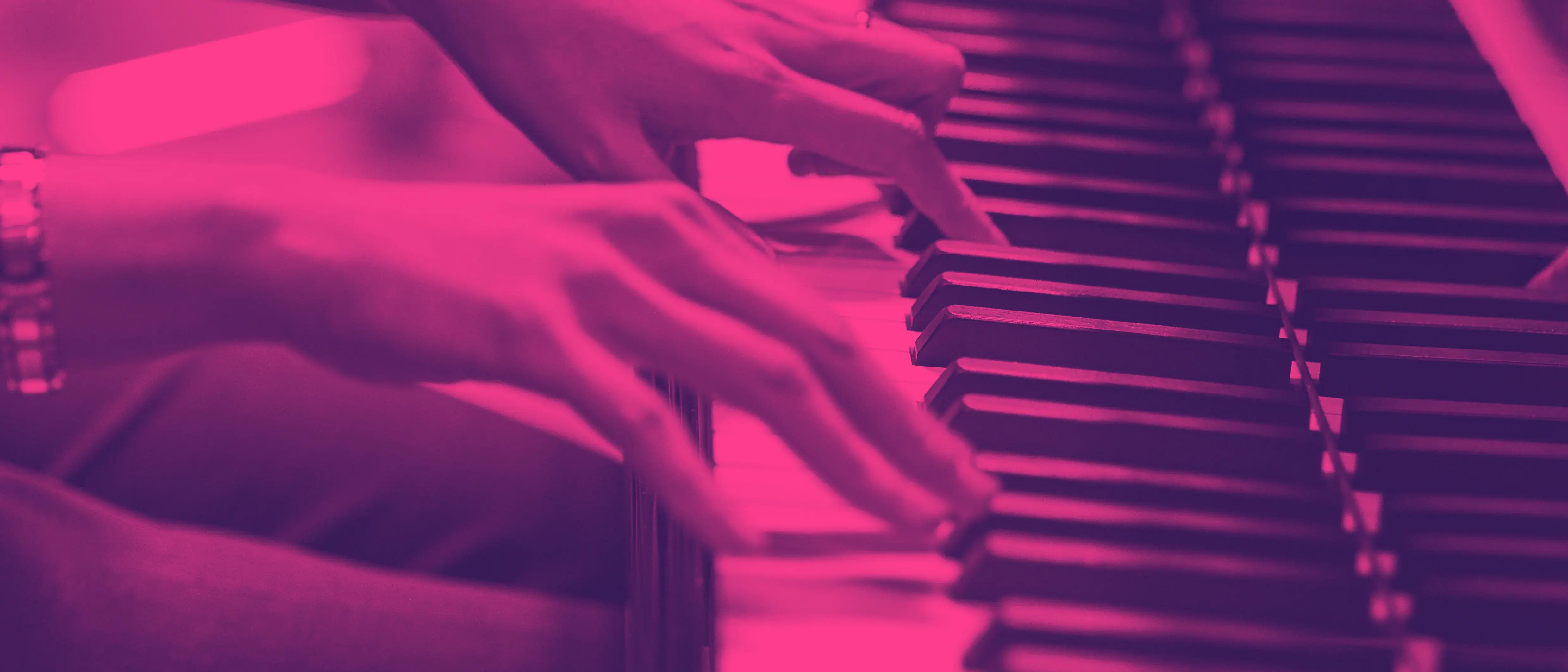 Nahaufnahme auf ein Klavier und zwei Hände, die das Instrument spielen. Das Bild ist mit einem pink-dunkelvioletten Duoton-Filter eingefärbt.